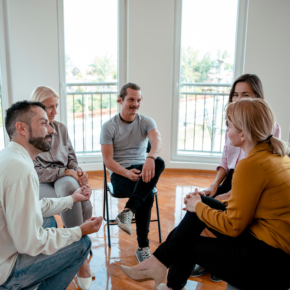 People sitting together in empty room talking and solving problems