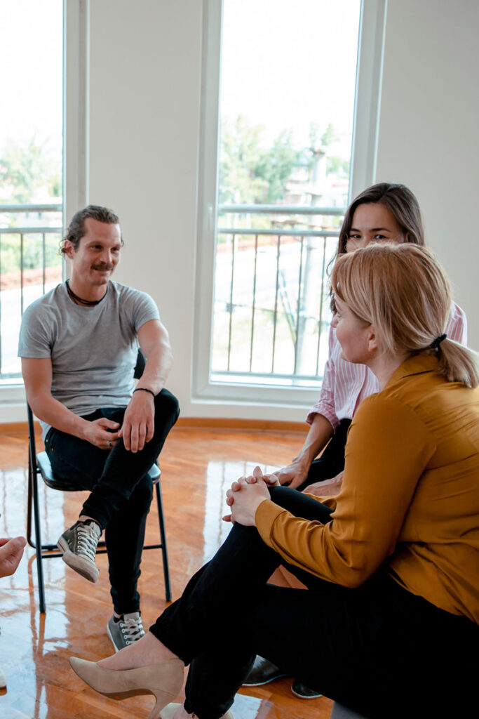 People sitting together in empty room talking and solving problems